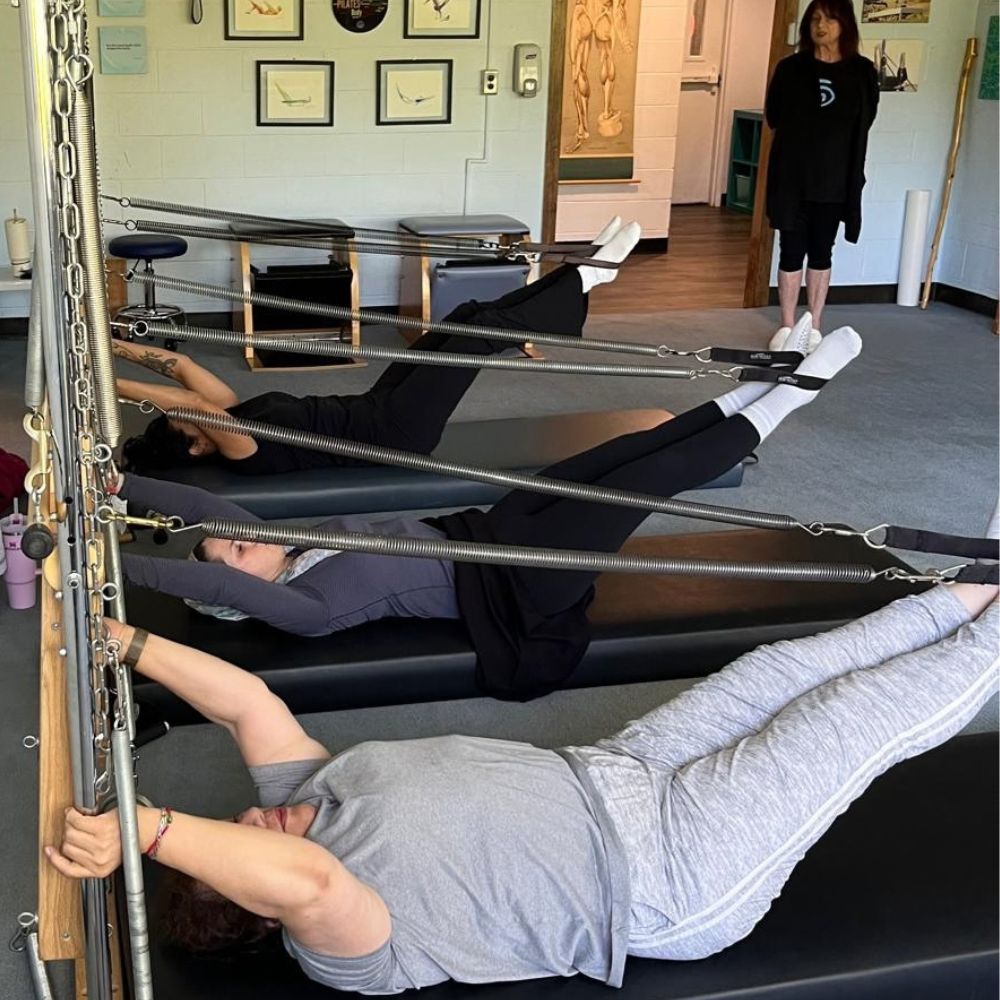 An instructor guiding a client through a Tower exercise