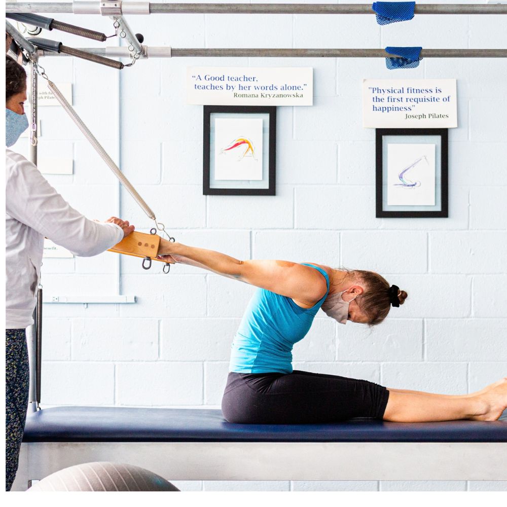 Mind Body instructor guiding a client on the Tower